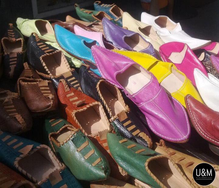 Weisse marokkanische Schuhpaare mit spitzigen Endungen in allen Regenbogenfarben